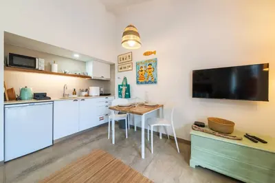 a kitchen with a table and a tv on the wall at Casa Velha da Lagoa - Peixe by Mth in Ponta do Sol