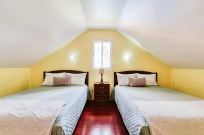 two beds in a room with yellow walls at Casa da Pedra by Amazing Madeira in Santana