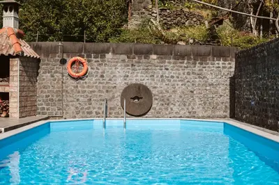 a swimming pool in front of a brick wall at Casa da Pedra by Amazing Madeira in Santana