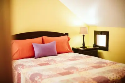 a bedroom with a bed with orange and purple pillows at Casa da Pedra by Amazing Madeira in Santana