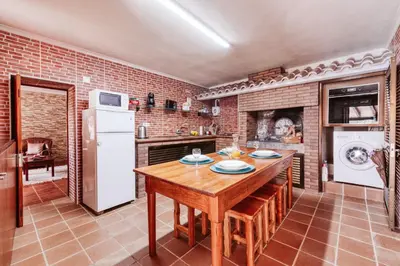 a kitchen with a wooden table and a refrigerator at Casa da Pedra by Amazing Madeira in Santana