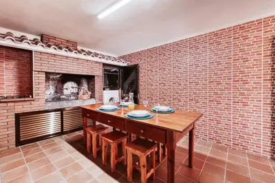 a dining room with a wooden table and a brick wall at Casa da Pedra by Amazing Madeira in Santana