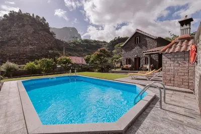 a pool in front of a house with a mountain at Casa da Pedra by Amazing Madeira in Santana