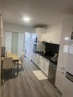 a kitchen with white cabinets and a table and a dining room at Relax accommodation in Funchal