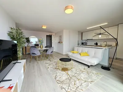 a living room with a white couch and a table at Garajau Palace Sea View II by Rentallido in Caniço