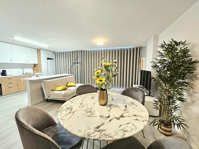 a living room with a table and some chairs at Garajau Palace Sea View II by Rentallido in Caniço
