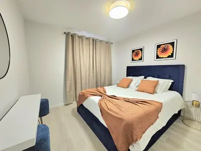a bedroom with a large bed with a blue headboard at Garajau Palace Sea View II by Rentallido in Caniço