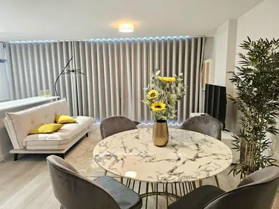 a living room with a table with a vase of flowers on it at Garajau Palace Sea View II by Rentallido in Caniço