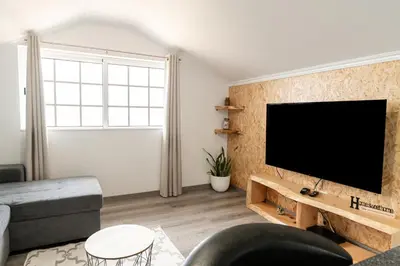 a living room with a flat screen tv on a wall at Barreiro View in Ribeira Brava