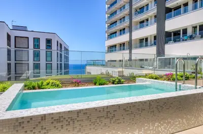 a swimming pool in front of a building at Funchal Acqua Blue 3H, a Home in Madeira in Funchal