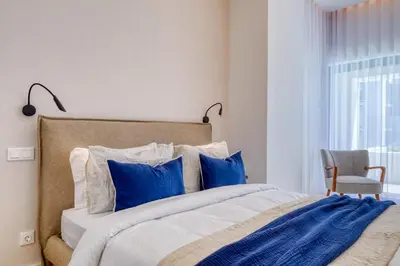 a bedroom with a large bed with blue pillows at Funchal Acqua Blue 3H, a Home in Madeira in Funchal