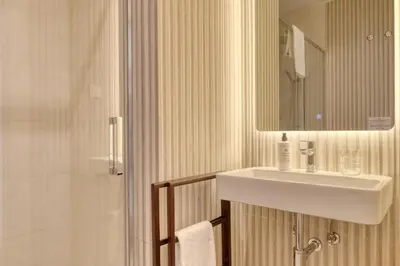 a bathroom with a sink and a shower with a mirror at Funchal Acqua Blue 3H, a Home in Madeira in Funchal