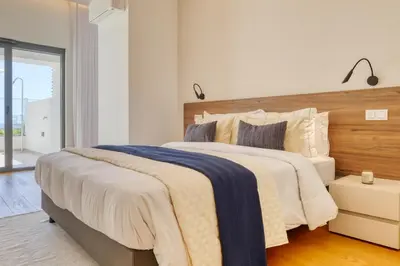 a bedroom with a large bed with a wooden headboard at Funchal Acqua Blue 3H, a Home in Madeira in Funchal