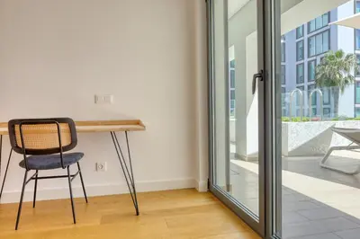 a chair sitting at a desk in a room with a glass door at Funchal Acqua Blue 3H, a Home in Madeira in Funchal