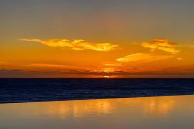 a sunset over the ocean with the sun setting at Funchal Acqua Blue 3H, a Home in Madeira in Funchal