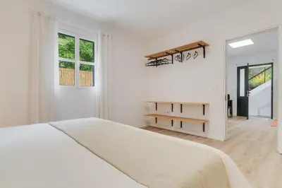 a white bedroom with a large bed and a window at Casa Teixeira by Holiday Rental Madeira in Senhora do Rosário