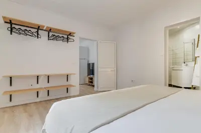 a white bedroom with a large bed and a bathroom at Casa Teixeira by Holiday Rental Madeira in Senhora do Rosário
