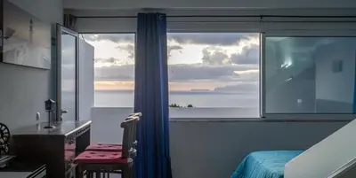 a bedroom with a window with a view of the ocean at Apartamento Gois in Machico