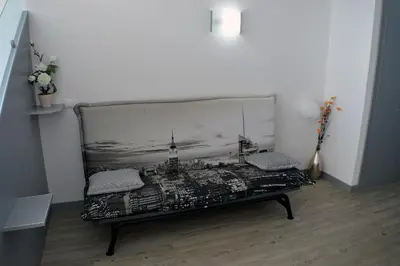 a bench in a room with a picture of a city at Apartamento Gois in Machico