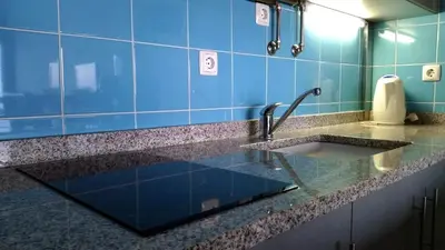 a sink in a bathroom with blue tiles at Apartamento Gois in Machico