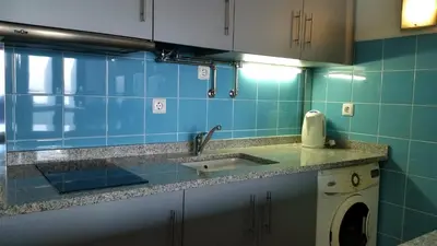 a kitchen with a sink and blue tiles at Apartamento Gois in Machico