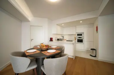 a dining room with a table and chairs and a large window at Madeira Acqua Suite in Funchal