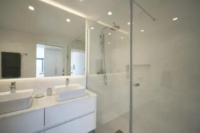 a bathroom with two sinks and a toilet and a mirror at Madeira Acqua Suite in Funchal