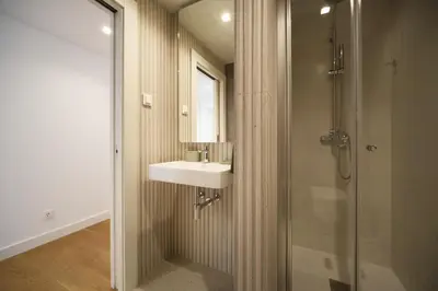 a kitchen with white cabinets and a table with chairs at Madeira Acqua Suite in Funchal
