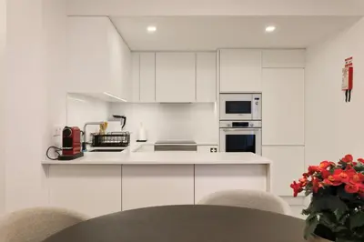 a white kitchen with white cabinets and appliances at Madeira Acqua Suite in Funchal