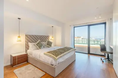 a bedroom with a bed and a large window at Oceanview Penthouse in Funchal in Funchal