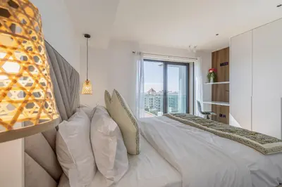 a white bedroom with a bed with a large window at Oceanview Penthouse in Funchal in Funchal