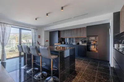 a kitchen with a bar with stools at Oceanview Penthouse in Funchal in Funchal