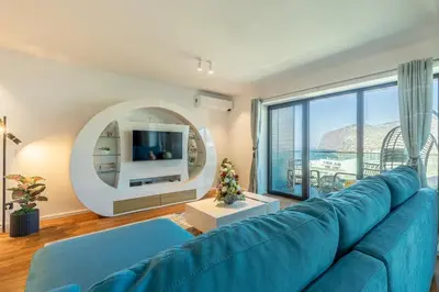 a blue couch in a living room with a large window at Oceanview Penthouse in Funchal in Funchal