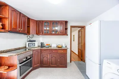 a kitchen with wooden cabinets and a white refrigerator at Pena Vista Mar Funchal by YOUR KEY in Funchal
