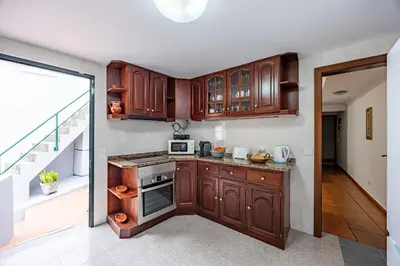 a kitchen with wooden cabinets and a balcony at Pena Vista Mar Funchal by YOUR KEY in Funchal