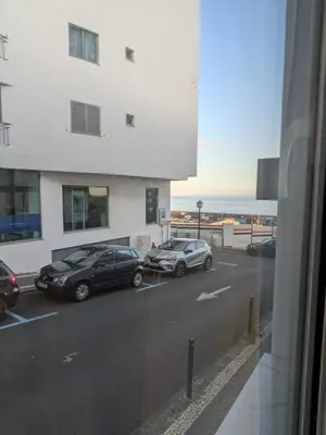 two cars parked in a parking lot next to a building at Princess Flower in Funchal