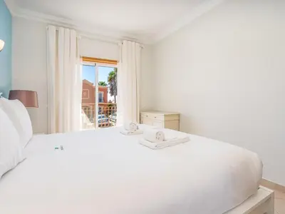 a white bedroom with a large white bed and a window at Relax and golf at Boavista Golf Spa Resort #1968 in Lagos