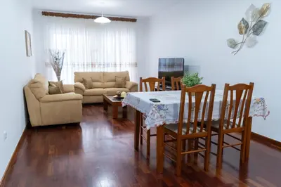 a living room with a table and chairs and a couch at Apartamento Isabel Charmoso e bem localizado in Ribeira Brava