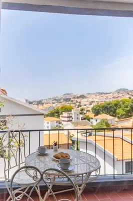 a table and chairs on a balcony with a view at Casa Nóbrega, By OP in Funchal