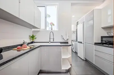 a white kitchen with white cabinets and a sink at Casa Nóbrega, By OP in Funchal