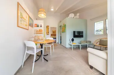 a dining room and living room with a table and chairs at Casa Velha da Lagoa - Pássaro - by Mth in Ponta do Sol