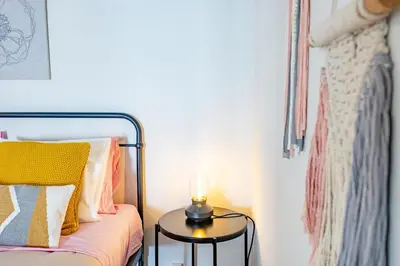 a room with a bed with a candle on a table at Hibiscus House by YOUR KEY in Calheta