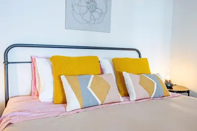 a bed with a bunch of pillows on it at Hibiscus House by YOUR KEY in Calheta