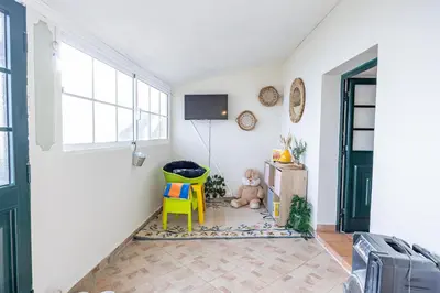 a room with a teddy bear and a yellow chair at Hibiscus House by YOUR KEY in Calheta