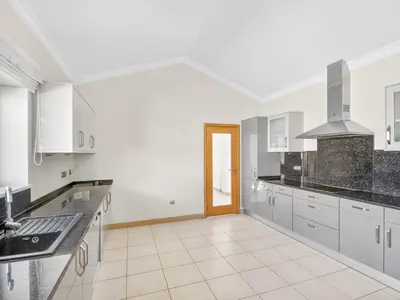 a large kitchen with gray cabinets and a stove at Vila Girassol in Lagos