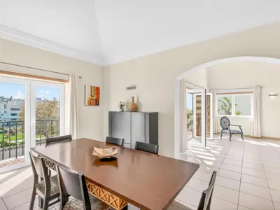 a dining room with a wooden table and chairs at Vila Limoeiro in Lagos