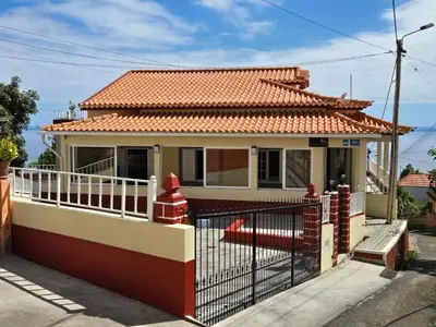 a house with a fence in front of it at Villa Pedro, Big House in Calheta