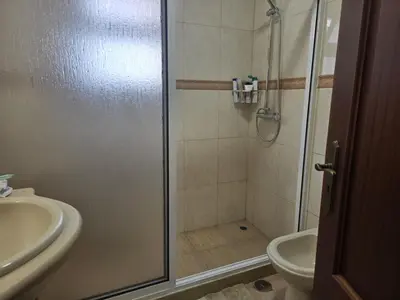 a bathroom with a shower with a toilet and a sink at Villa Pedro, Big House in Calheta