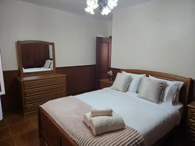 a bedroom with a large bed and a mirror at Villa Pedro, Big House in Calheta