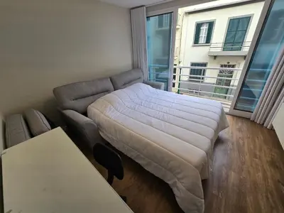 a bed and a couch in a room with a window at Zen Space in Funchal